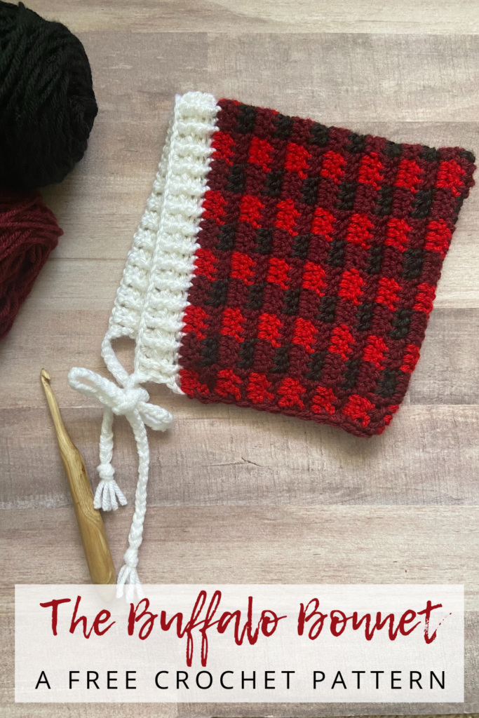 flat lay of crochet pixie bonnet with red buffalo plaid print