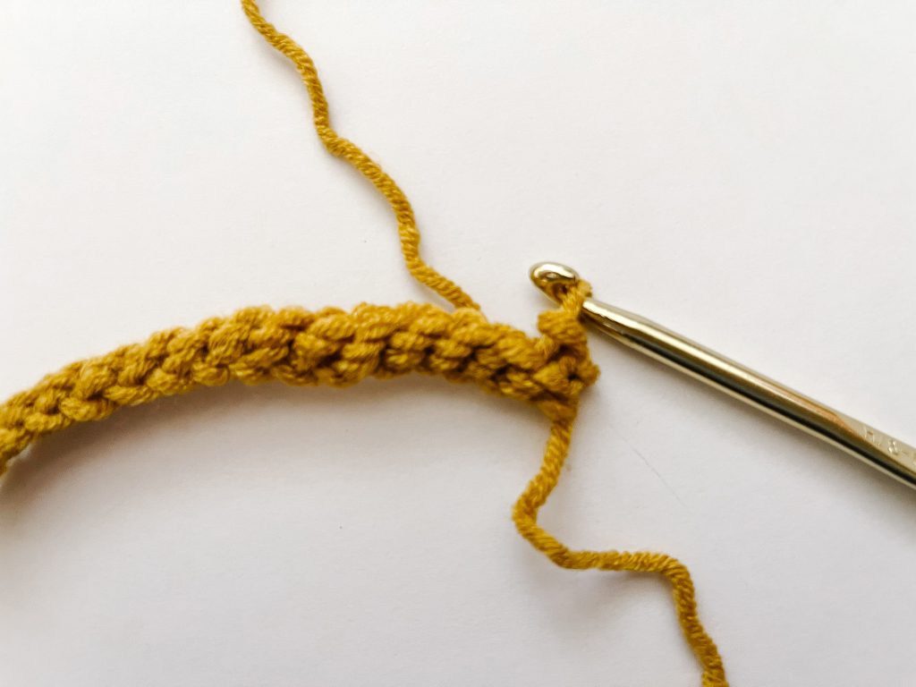 gold hook in yellow yarn showing slip stitch