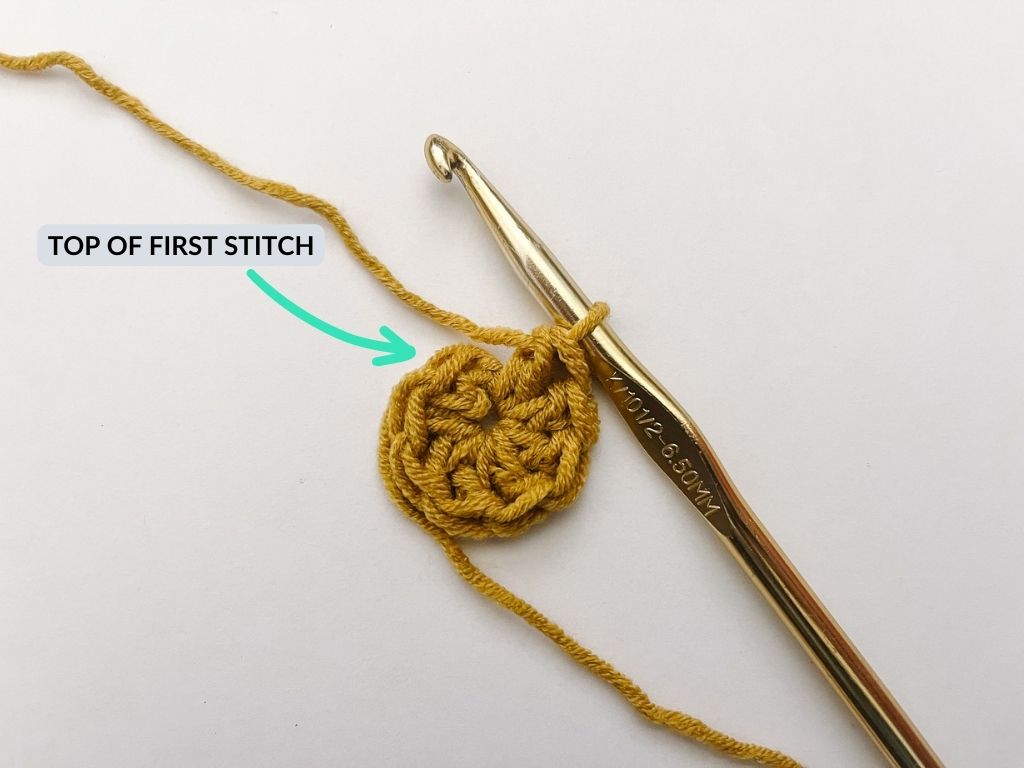 completed round of crochet stitches with gold crochet hook
