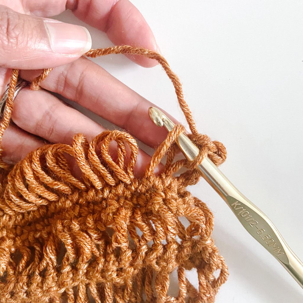 gold crochet hook in drop stitch loop