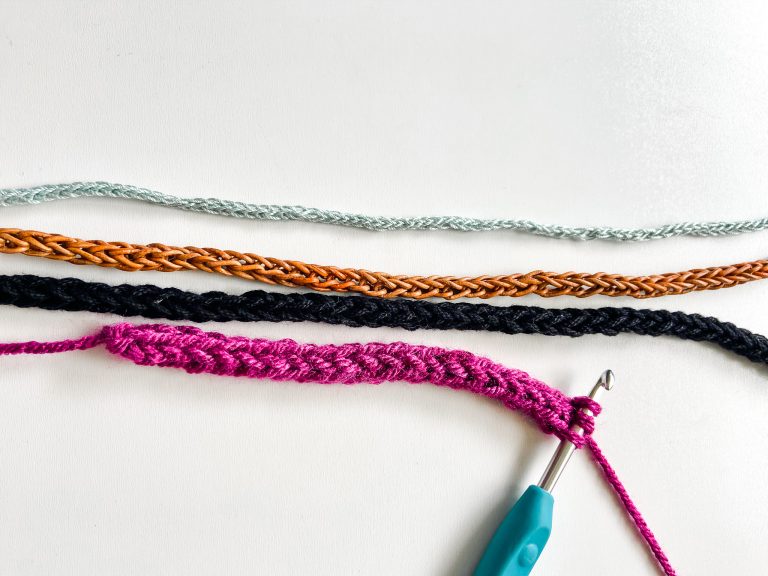 four crochet i-cords in various colors and sizes on white background